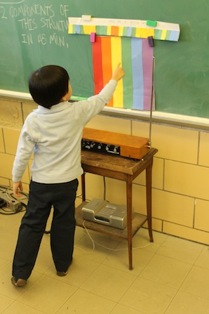 child pointing to color and playing theremin